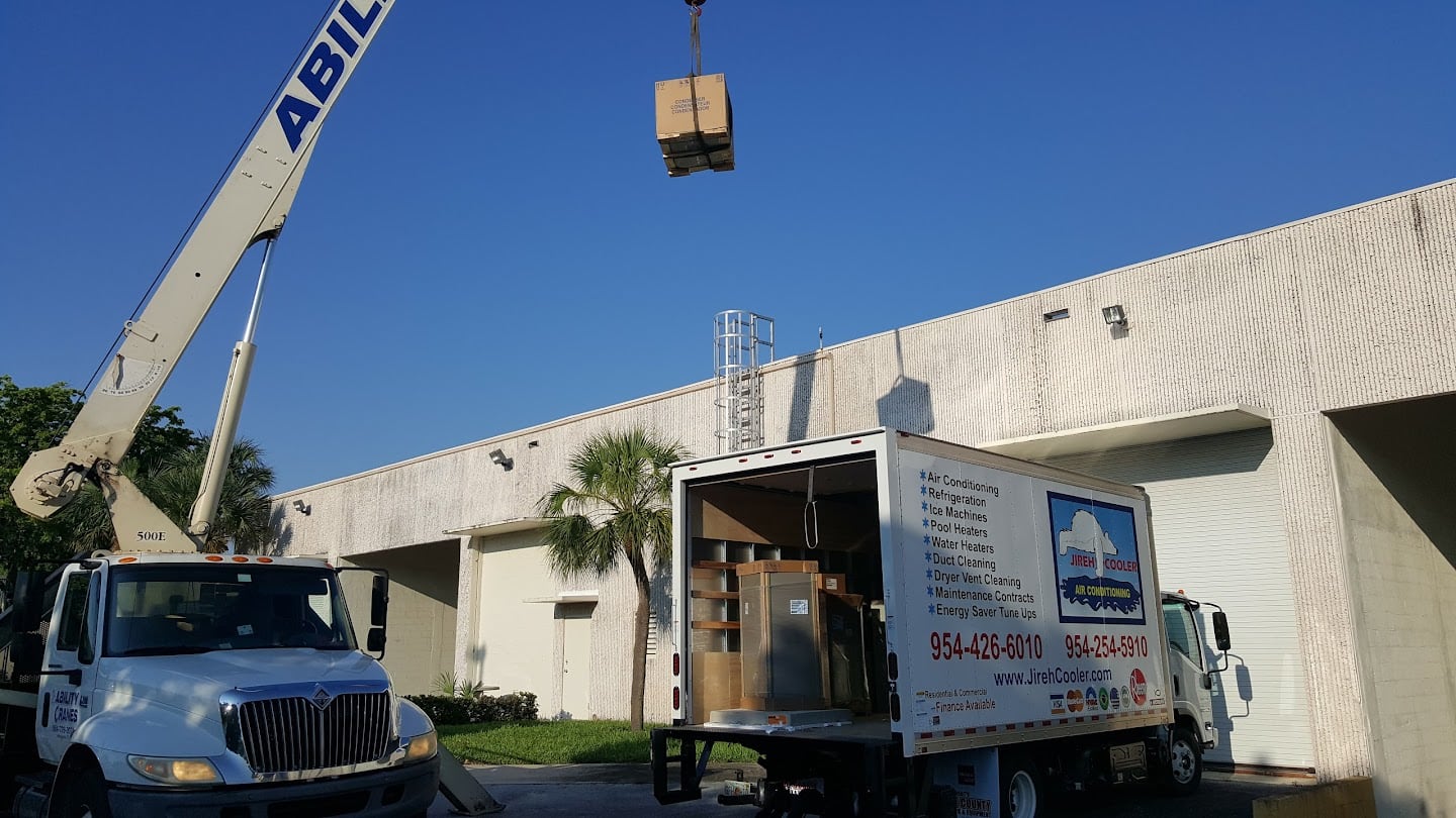 Crane lifting a commercial HVAC unit onto a rooftop at a Jireh Cooler jobsite